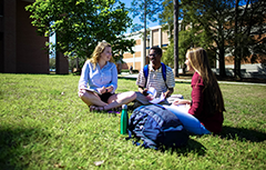 三个学生坐在校园的地上
